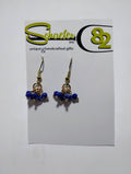 Gold earrings and clusters of navy blue sparkly beads
