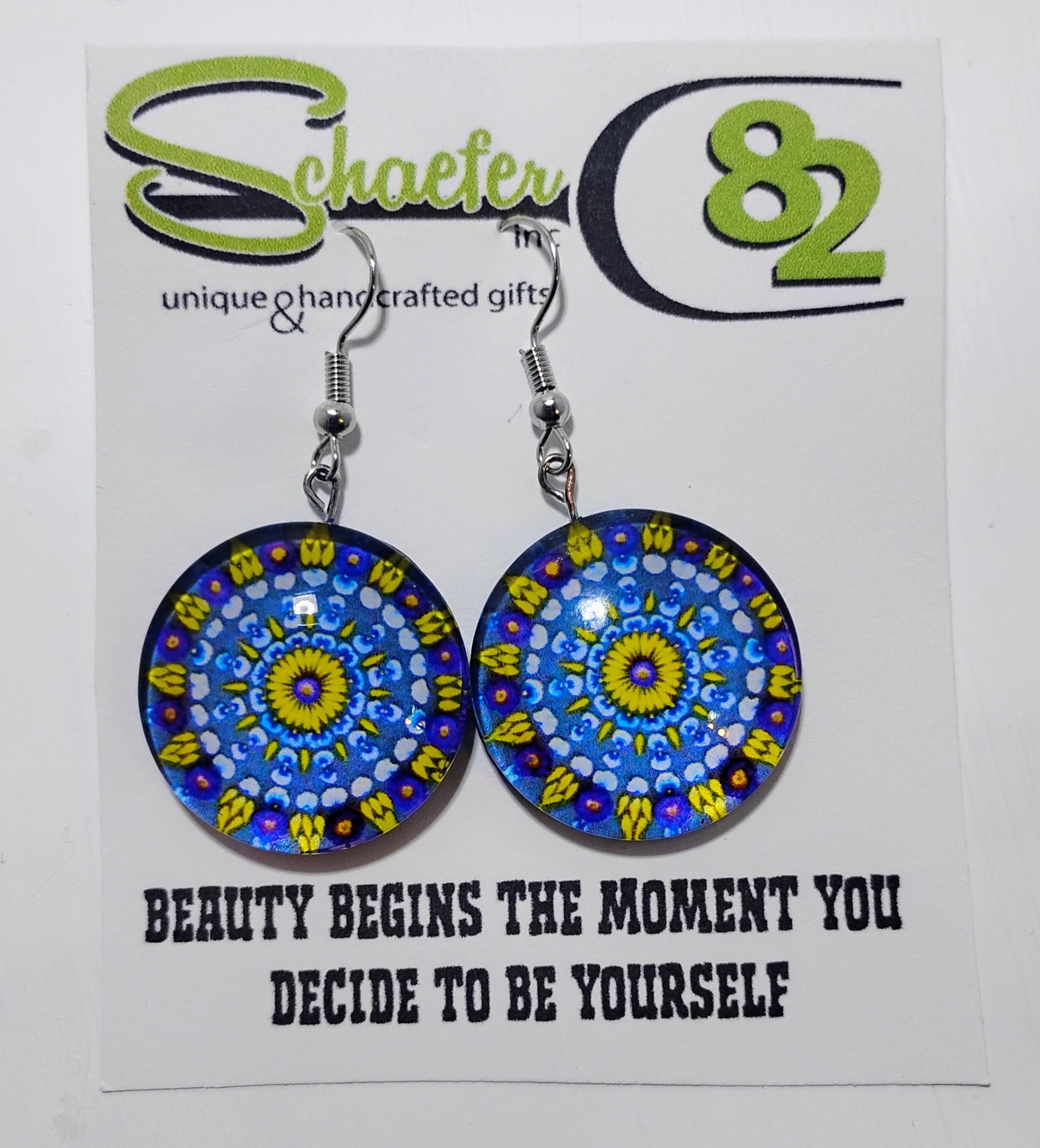 Handcrafted blue and yellow mandala disc earrings with a swirl pattern. 