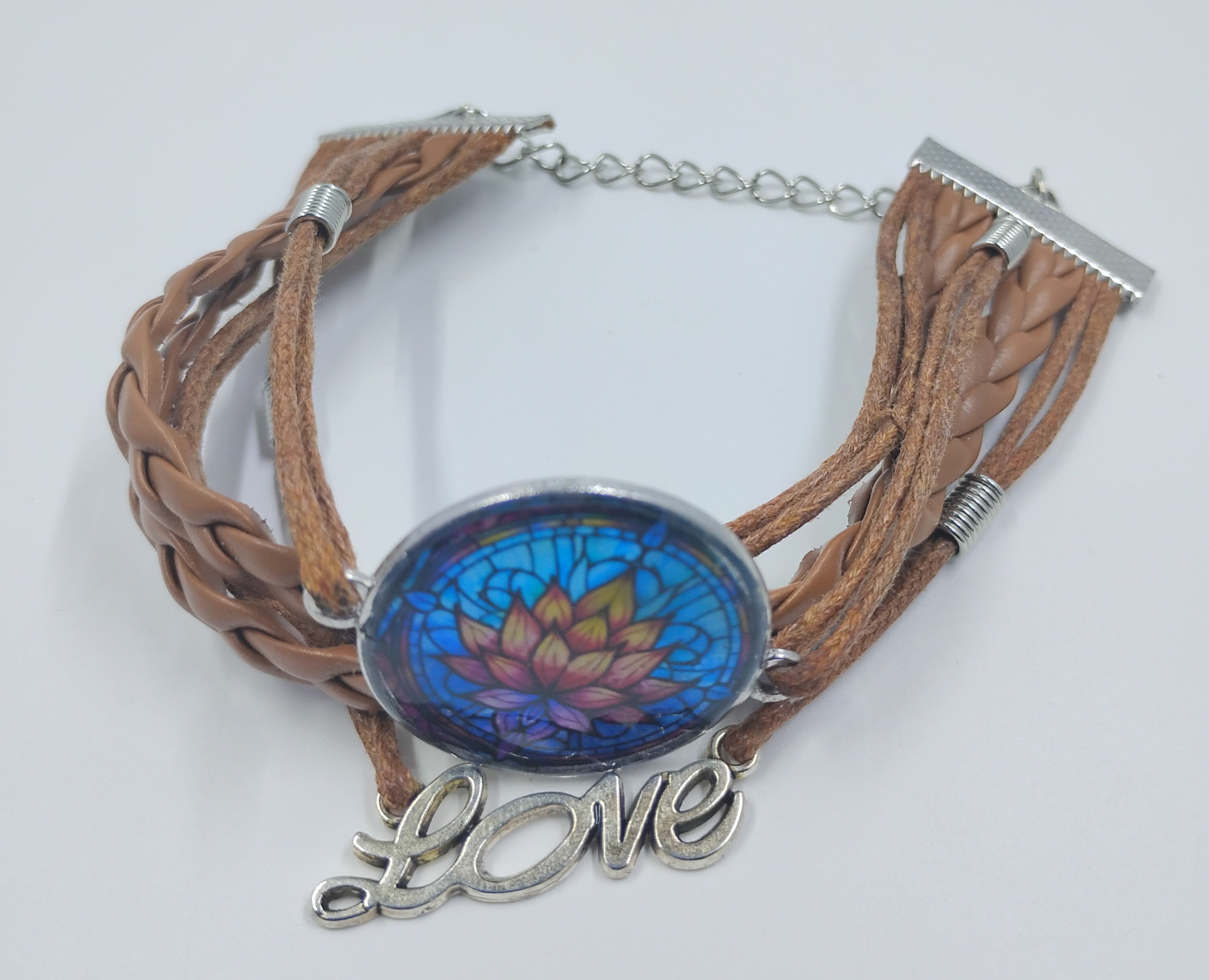Handcrafted leather bracelet that has the colorful image of a lotus in the center and the word love.