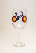 Handcrafted wine glass with a bike design, made to resemble the Colorado flag.