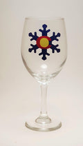 Handcrafted wine glass with a snowflake design, which is made to resemble the Colorado flag.