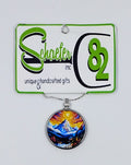 Handcrafted circular necklace with a colorful sunset and beautiful mountains in the background. 