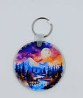 Handcrafted circle keychain with a beautiful night sky and mountains with a river in the forefront. 
