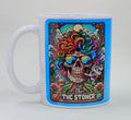 Handcrafted mug with a skeleton with rainbow hair, smoking a joint, and it says "the stoner" on the bottom. Very vibrant and colorful mug