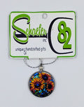 Handcrafted circular necklace with a colorful sunflower image.