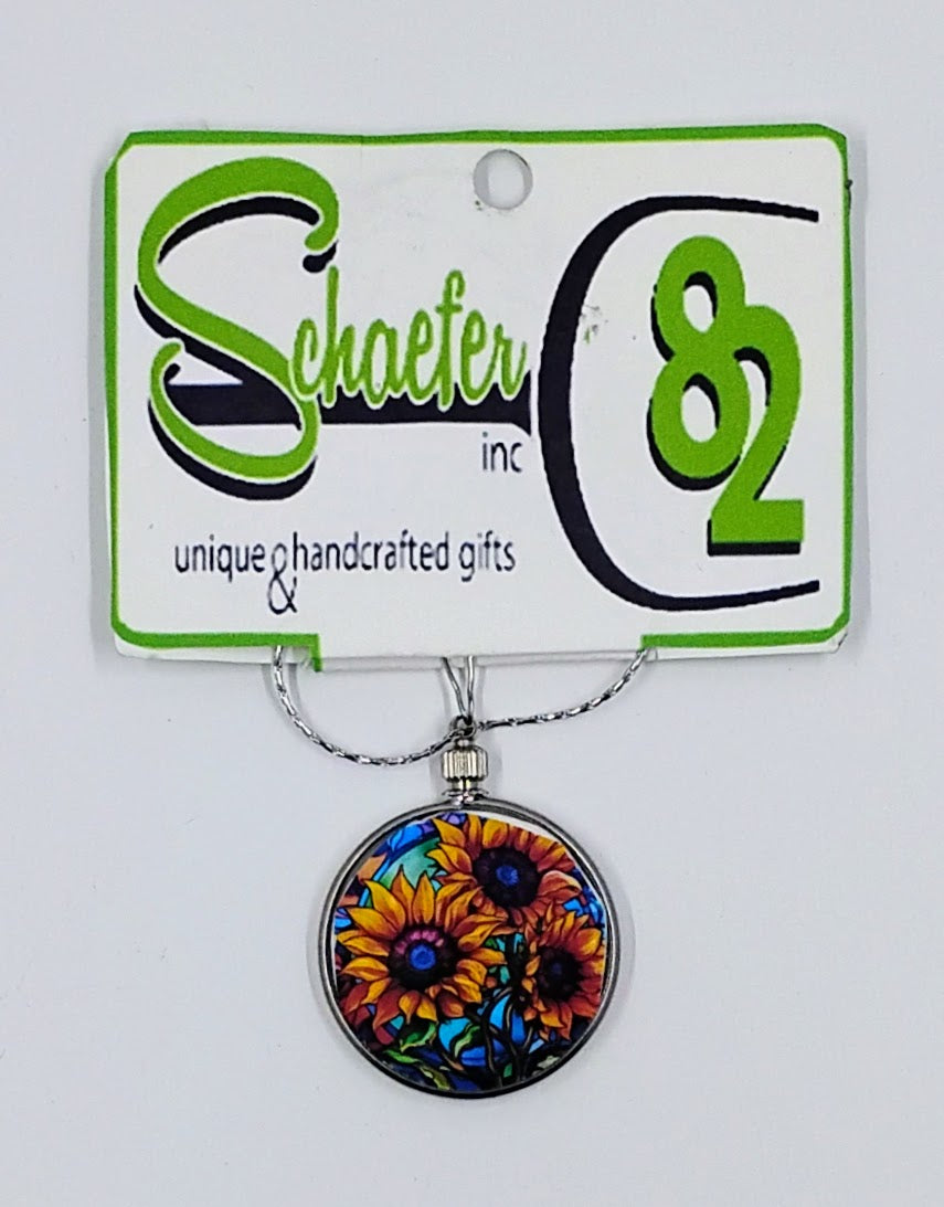 Handcrafted circular necklace with a colorful sunflower image.