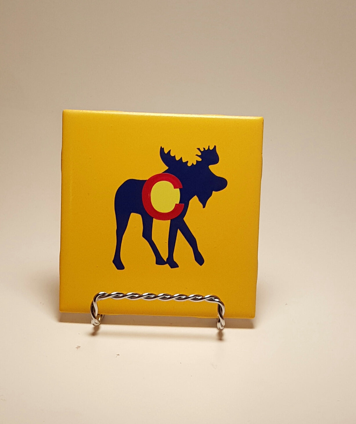 Handcrafted yellow coaster with a moose made to resemble the Colorado flag