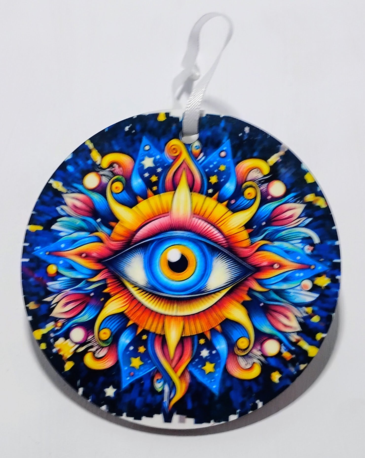 Handcrafted circular evil eye ornament with a bright colored background. 