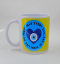 A coffee mug with an evil eye heart and the saying "may every evil eye in your life go blind" with a yellow background.