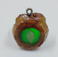 Handcrafted pendant from real pinecones and a glowing green center with a clear quartz stone. 