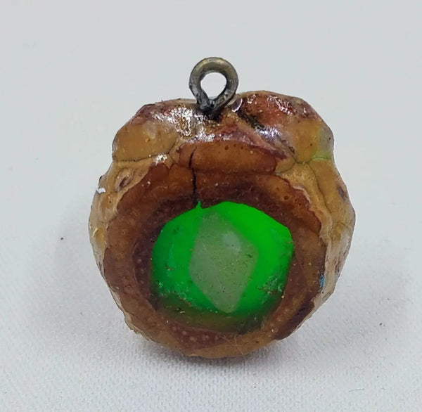 Handcrafted pendant from real pinecones and a glowing green center with a clear quartz stone. 