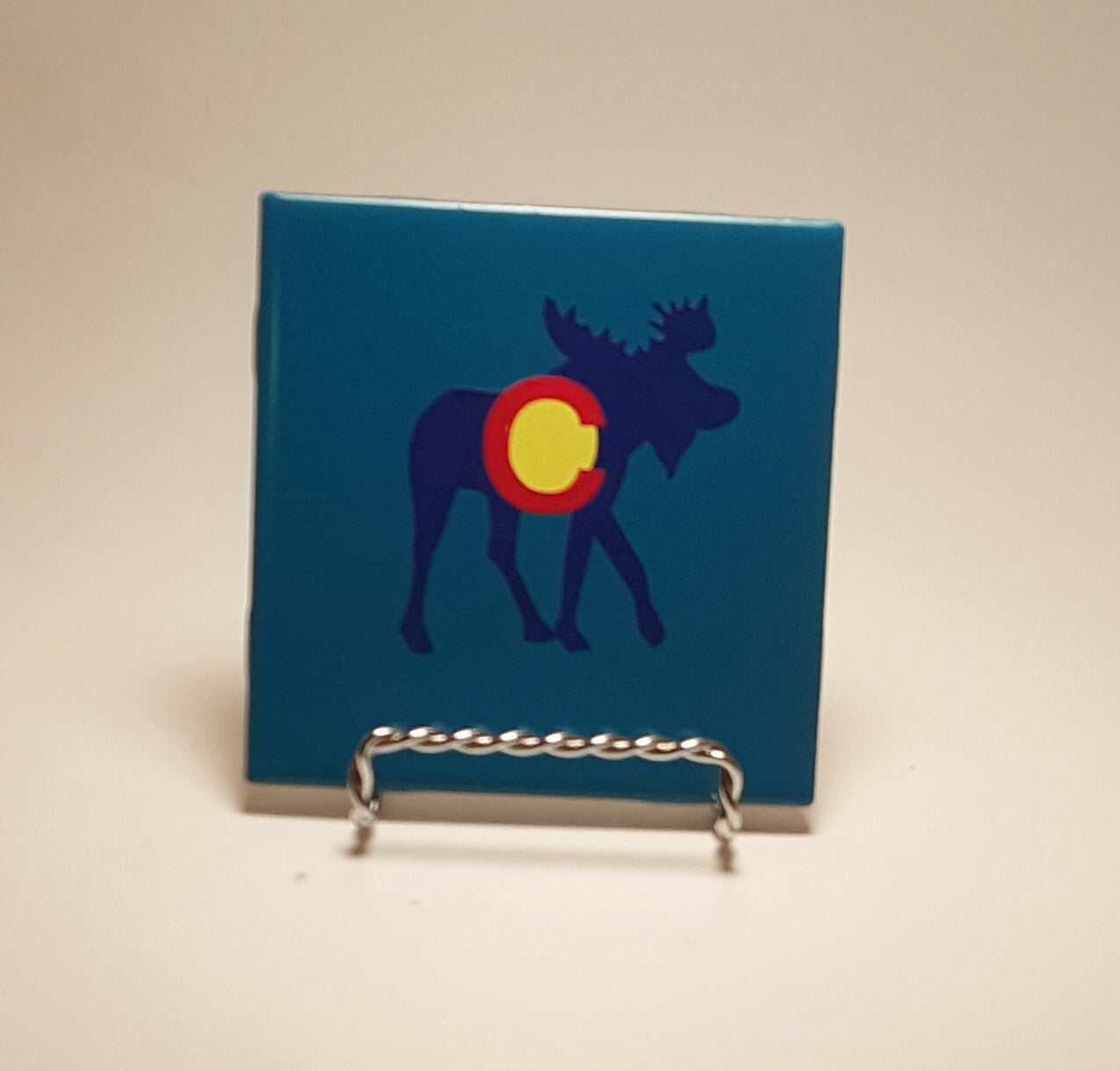 Handcrafted blue coaster with a moose design, which is meant to resemble the Colorado flag.