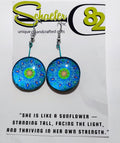 Handcrafted bright blue and lime green mandala earrings. with a baby blue background. 