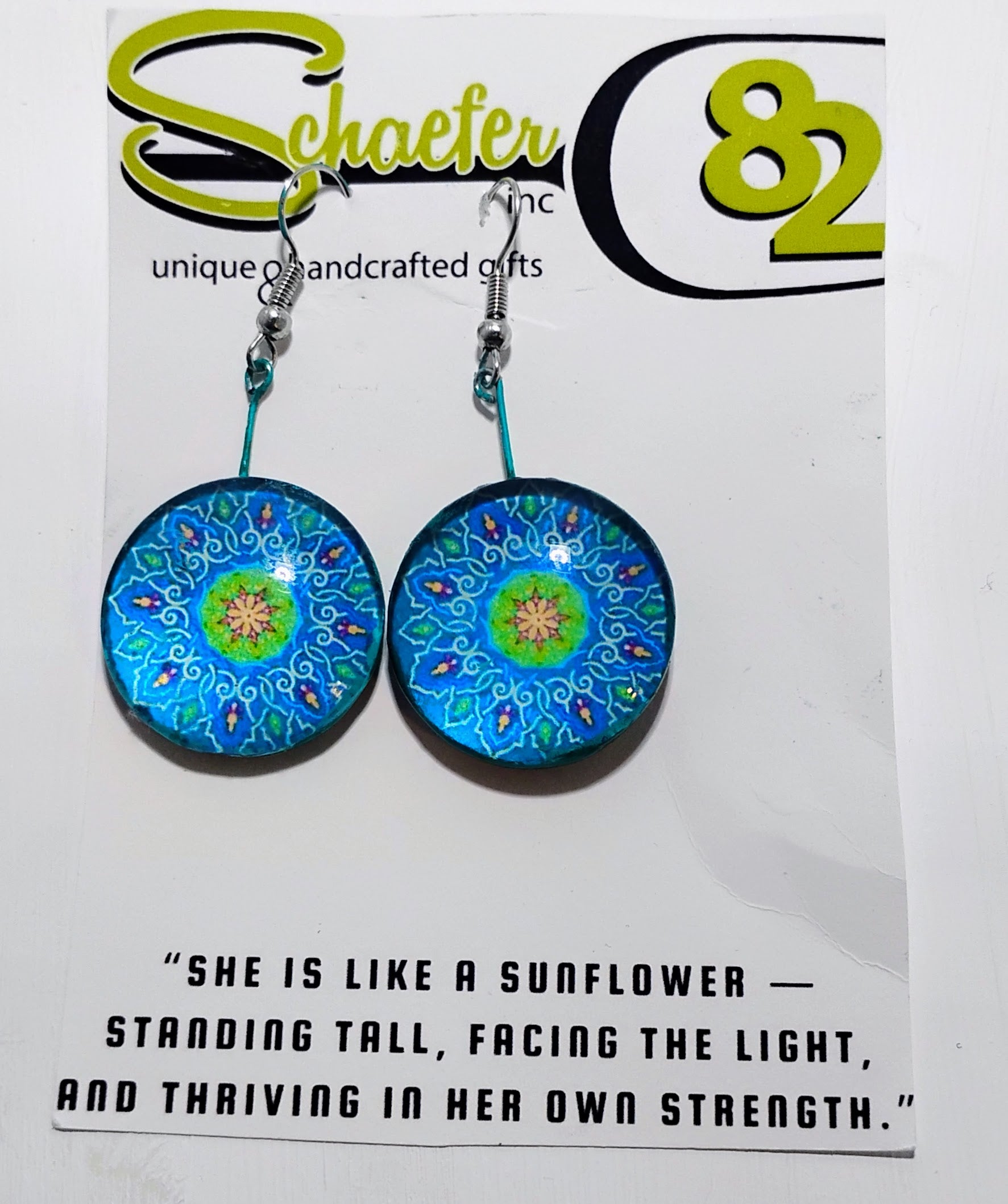 Handcrafted bright blue and lime green mandala earrings. with a baby blue background. 