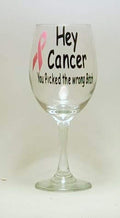 Handcrafted wine glass with the saying "Hey cancer, you picked the wrong *itch" and a pink ribon. 