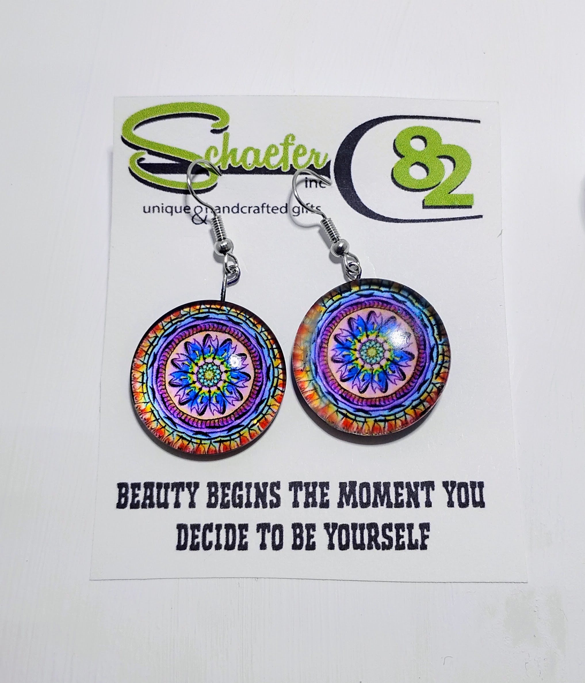 Handcrafted colorful flower mandala earrings using the colors orange, yellow, blue, purple and pink.