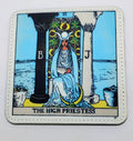 White pleather coaster that has the image from the tarot card "The high Priestess:, which has a woman sitting between two pillars. 