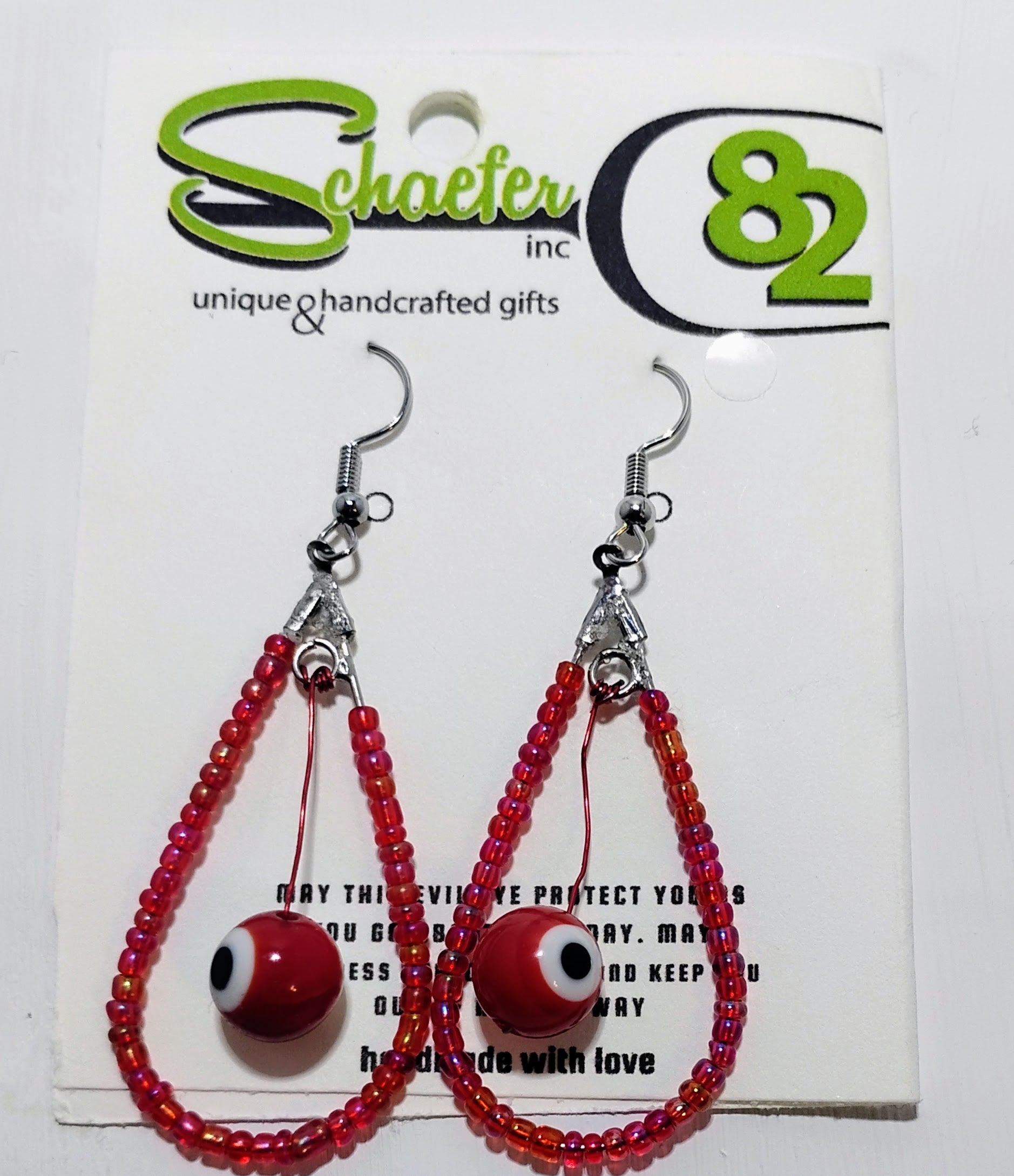 Handcrafted Evil eye earrings, which are beaded in red and then have dangly red evil eyes in the center. 