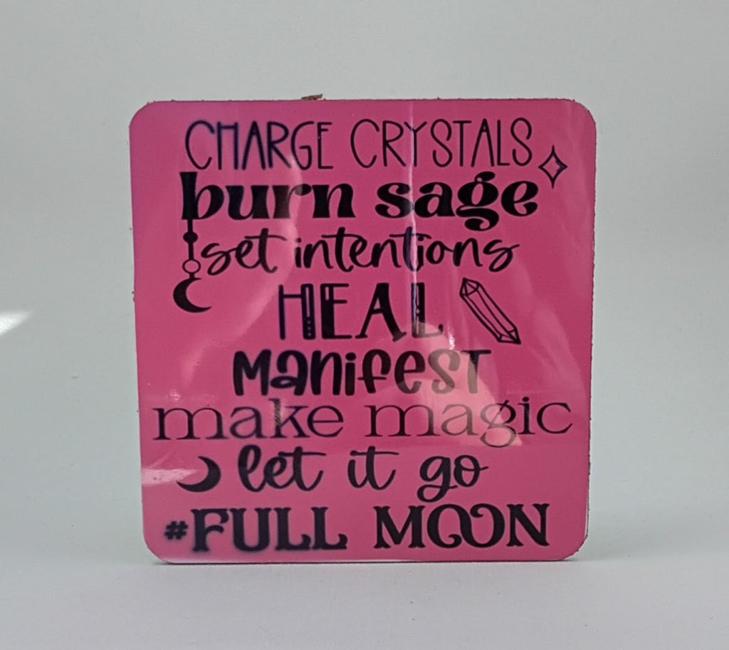 Handcrafted pink coaster with the saying Charge crystals, burn sage, set intentions, heal, manifest, make magic, let it go, full moon.
