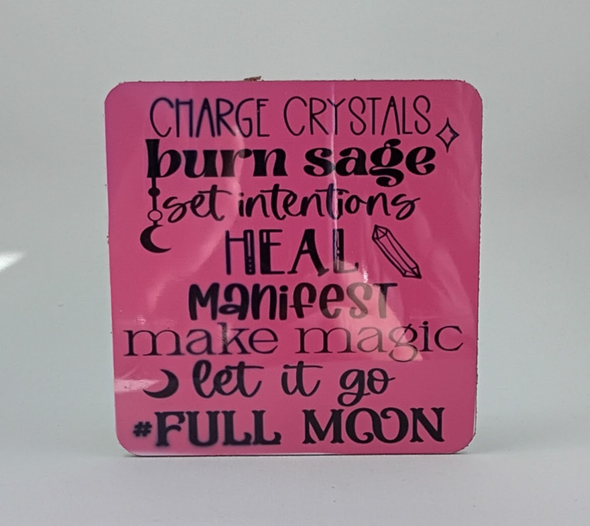 Handcrafted pink coaster with the saying Charge crystals, burn sage, set intentions, heal, manifest, make magic, let it go, full moon.
