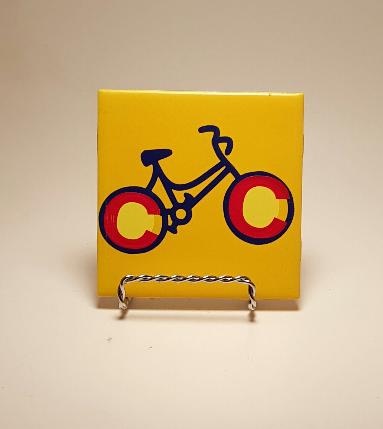Handcrafted Yellow coaster with a bike design which is made to resemble the Colorado flag.