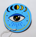 Light blue circular ornament with the image of an evil eye and the moon phases. 