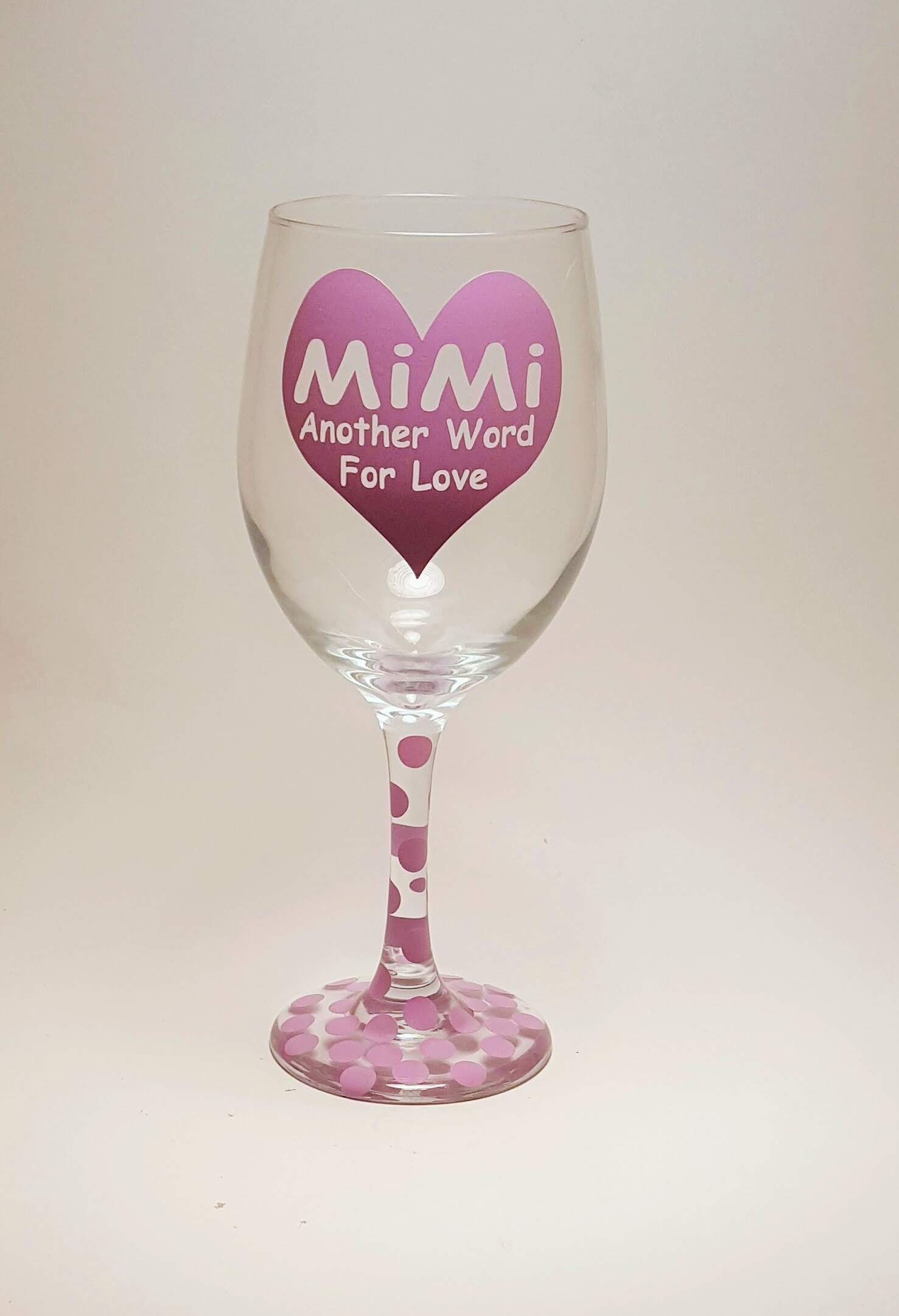 Handcrafted wine glass with a big heart and the quote "Mimi, another word for love" and covered in purple polka dots.