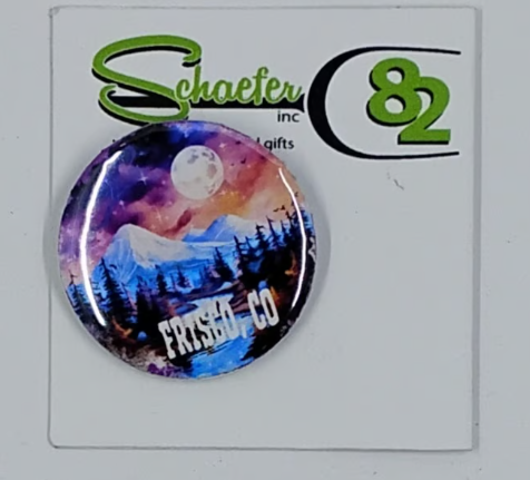 Small circular hat pin with a beautiful night sky and mountain scenery and large moon in the sky.  