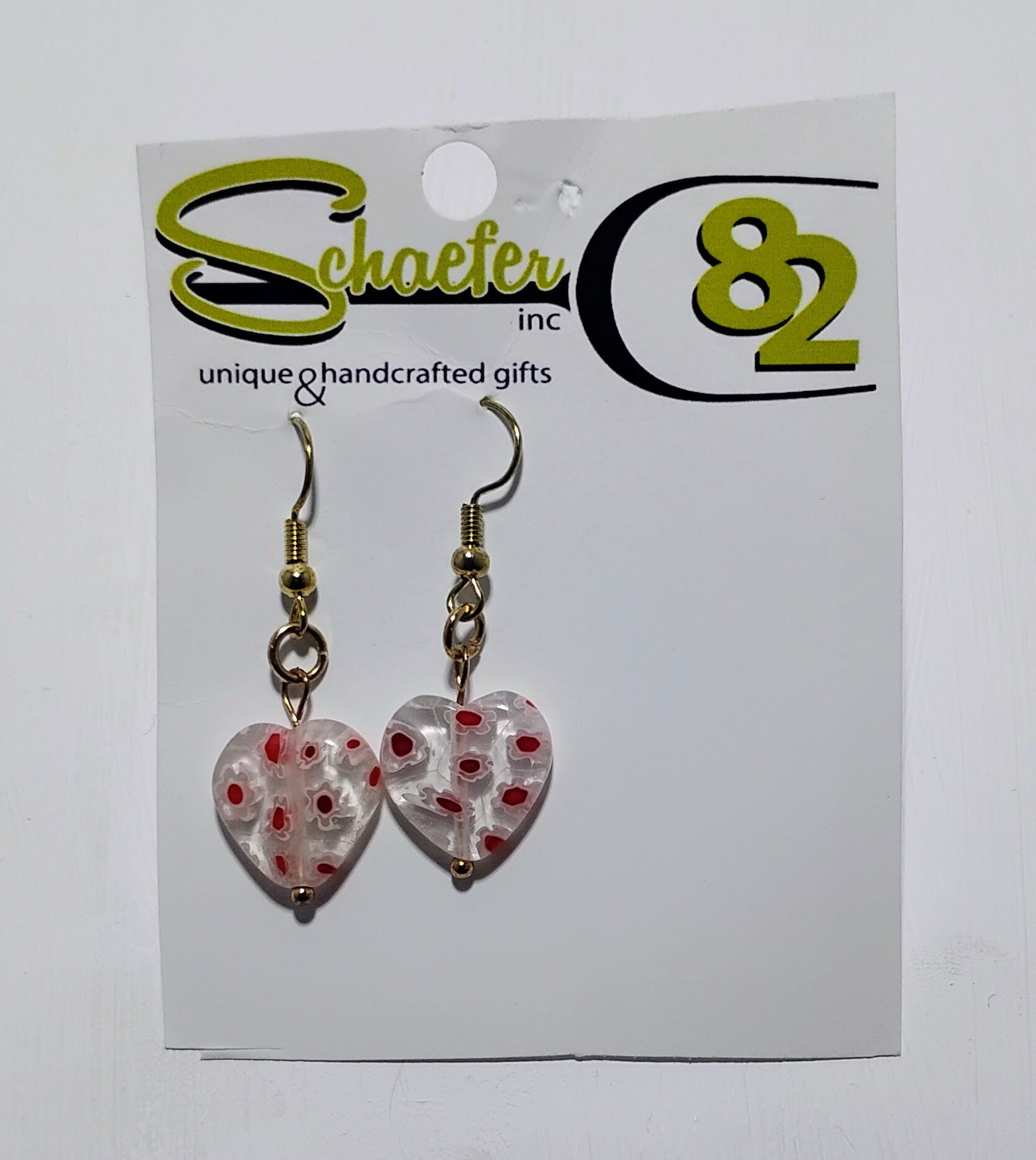 Small dangle earrings that have a clear heart filled with red and white hearts. 