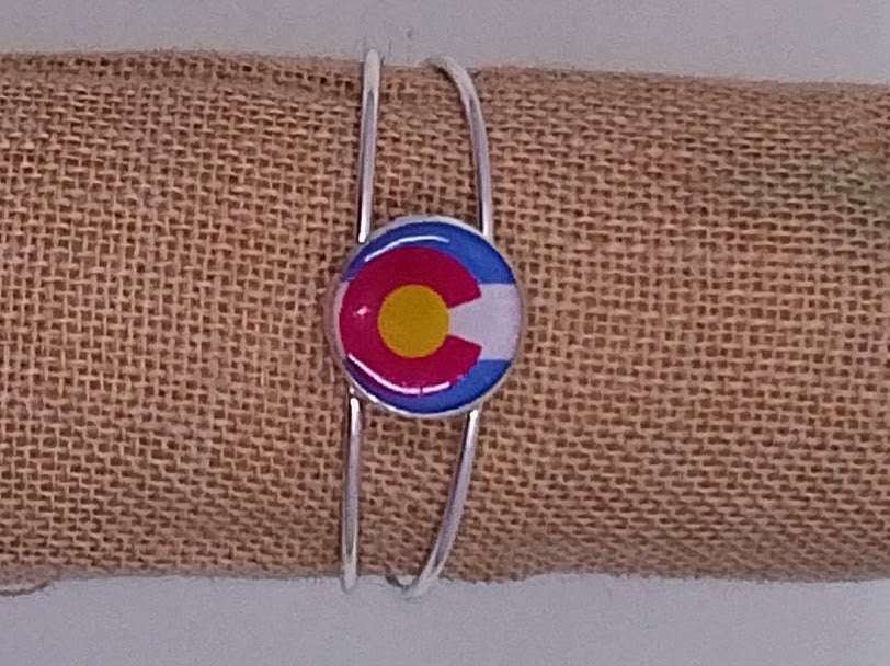 Handcrafted silver bangle bracelet with a colorful Colorado flag in the center. 