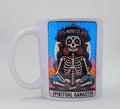 Handcrafted mug with a colorful image of a skeleton with a hat that says "manifest" and the bottom says "Spiritual Gangster"