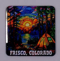 Colorful handcrafted Christmas ornament with a beautiful sunset and a lake with a tent in a beautiful forest.