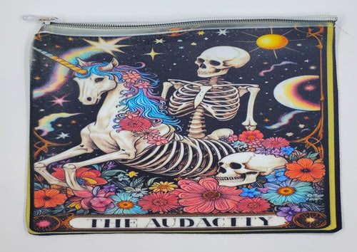 Handcrafted tarot inspired zipper bag with a skeleton riding a colorful unicorn, surrounded by colorful flowers and a night sky. The bottom says "the audacity".