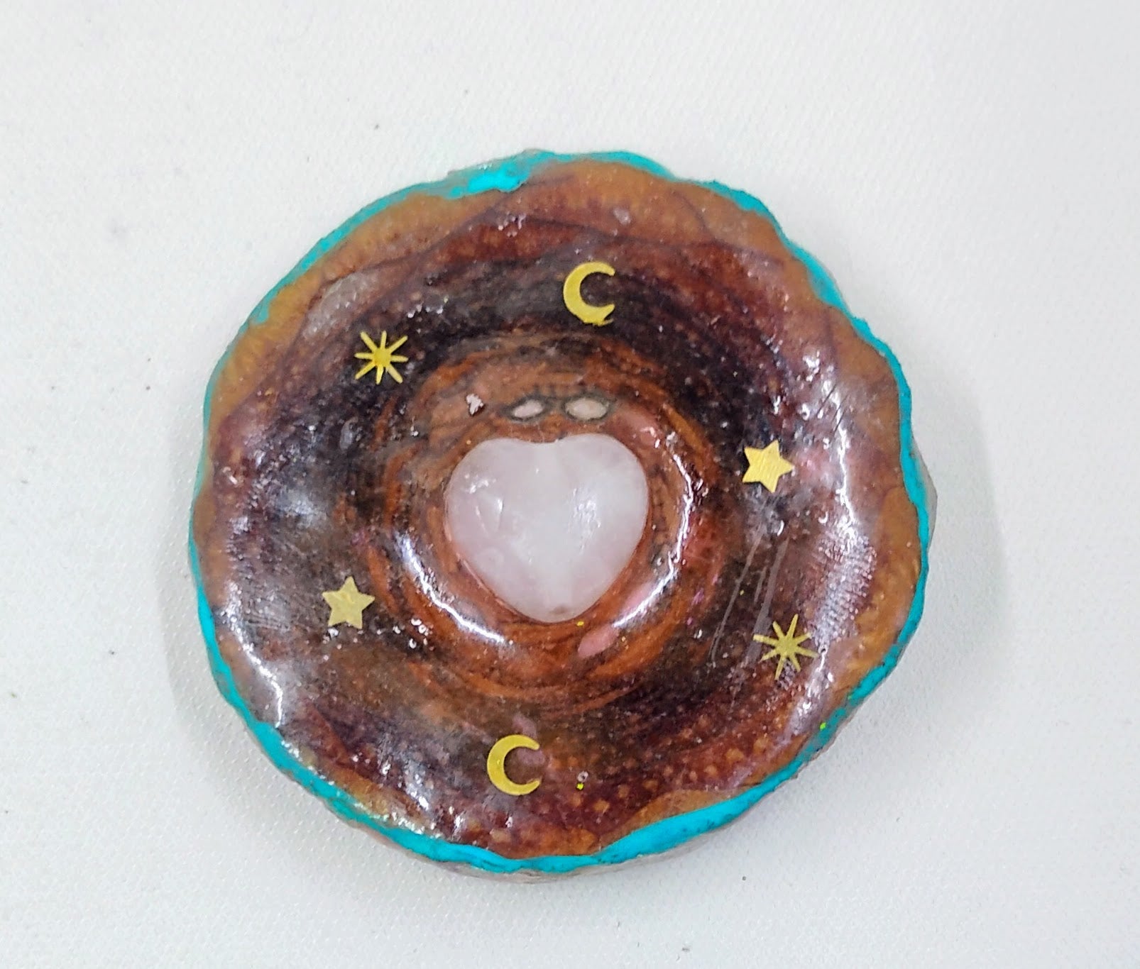 Handcrafted  third eye pinecone necklace with teal accents and gold moons and stars. 