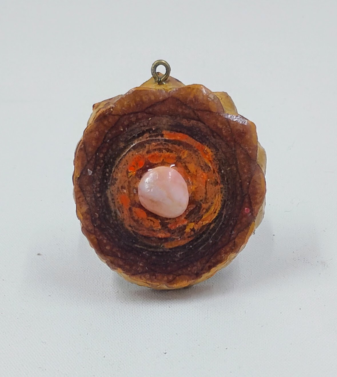 Third Eye pine cone pendant with orange accents and pink rose crystal center.