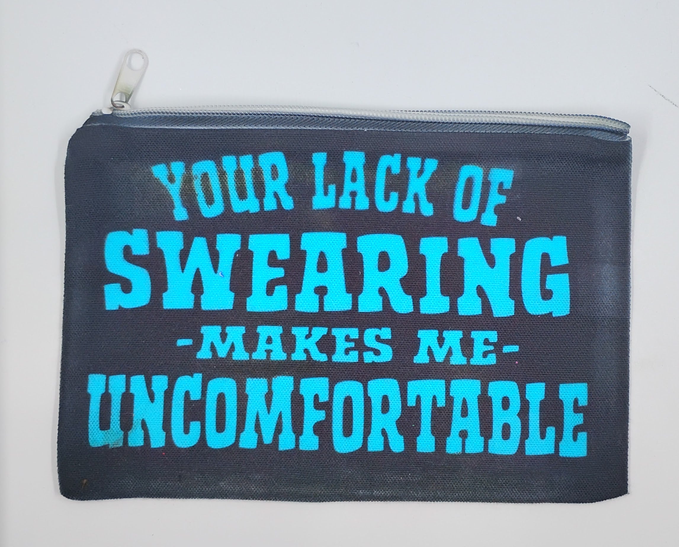 Handcrafted black zipper bag with bright blue wording that say "your lack of swearing makes me uncomfortable"