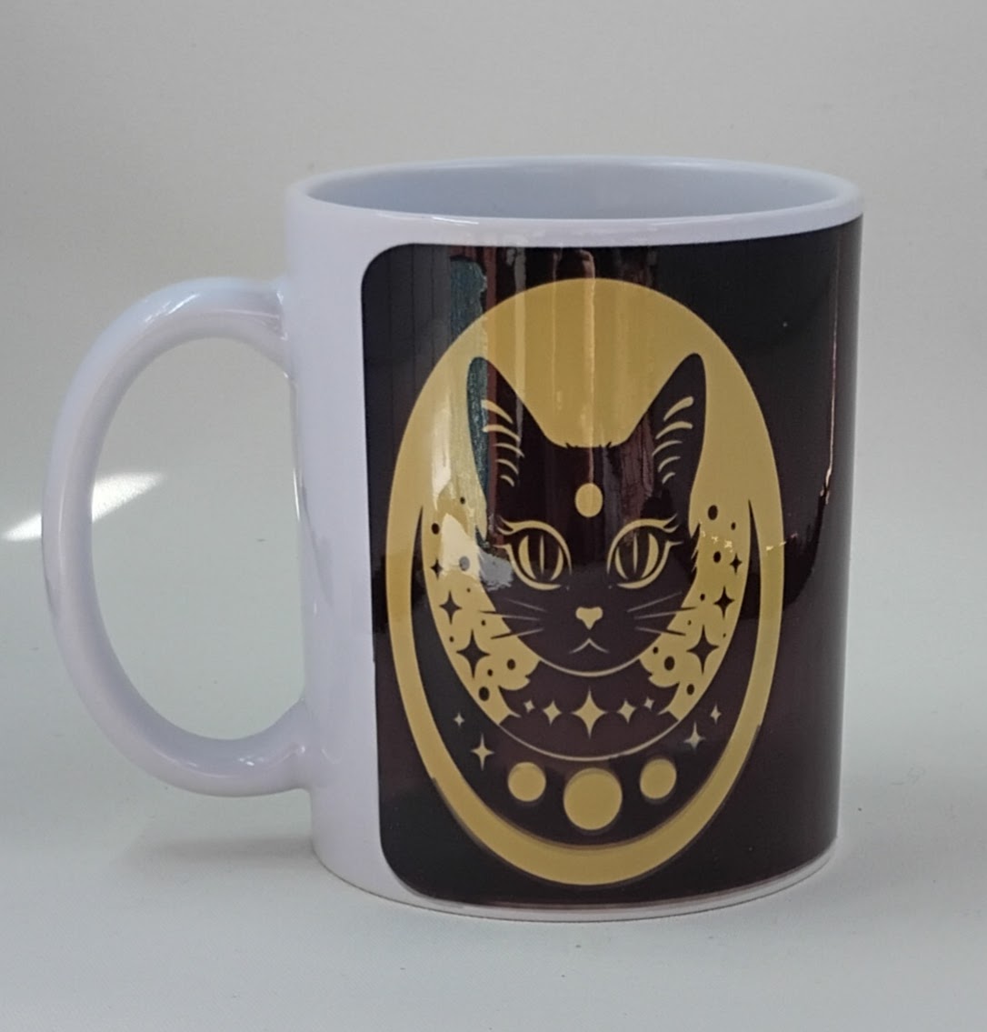 handcrafted coffee mug with a gold and black background and a black cat with moons and stars